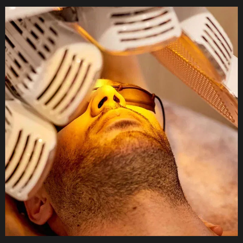 Closeup of LED light therapy on a hair restoration male client