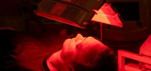 Face of Man client receiving a LED treatment to restore skin