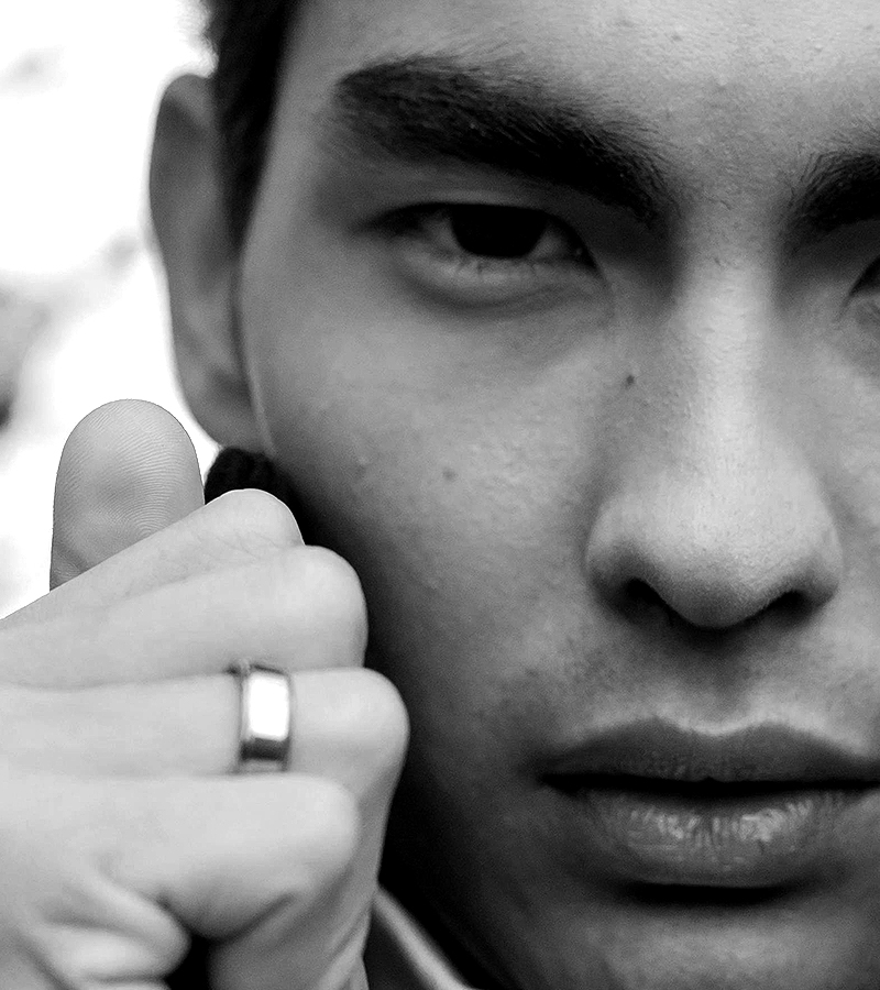 Man holding a device near ear.